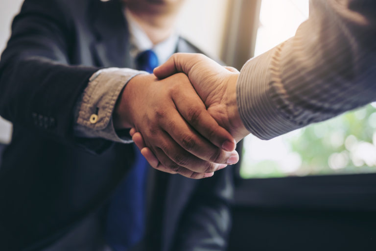 two-business-men-shaking-hands-during-a-meeting-to-sign-agreement-and